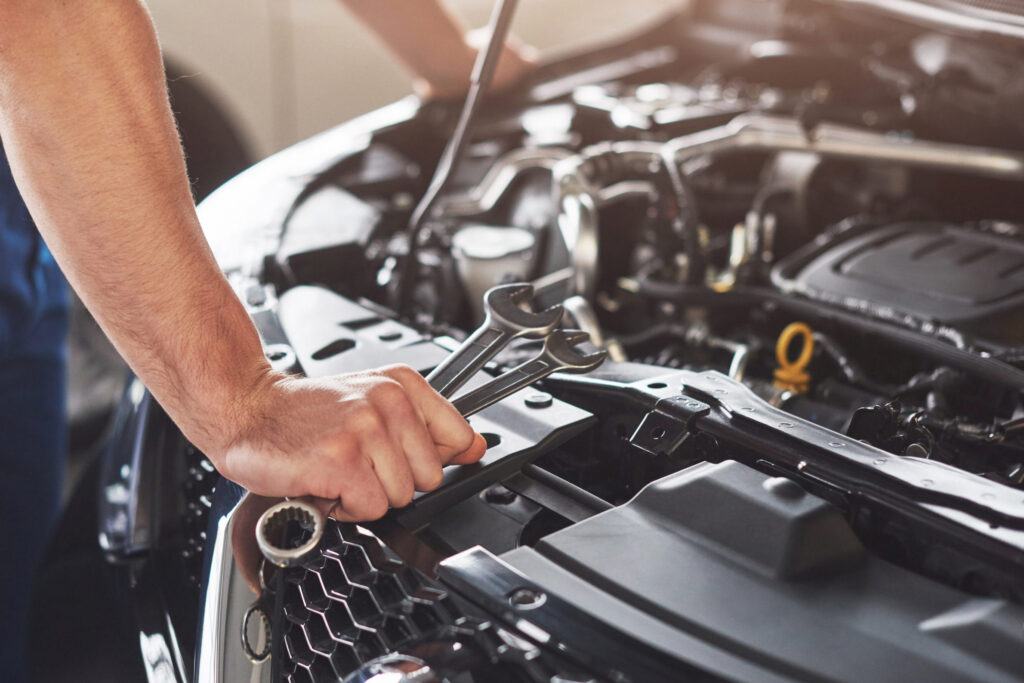 picture showing muscular car service worker repairing vehicle